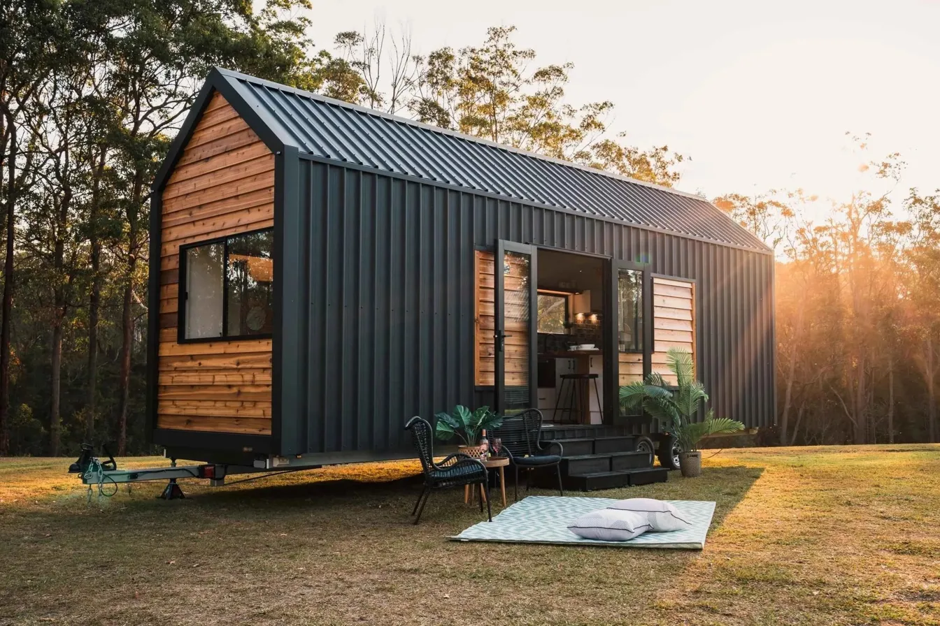 Modern cedar and steel tiny home at golden hour sunset