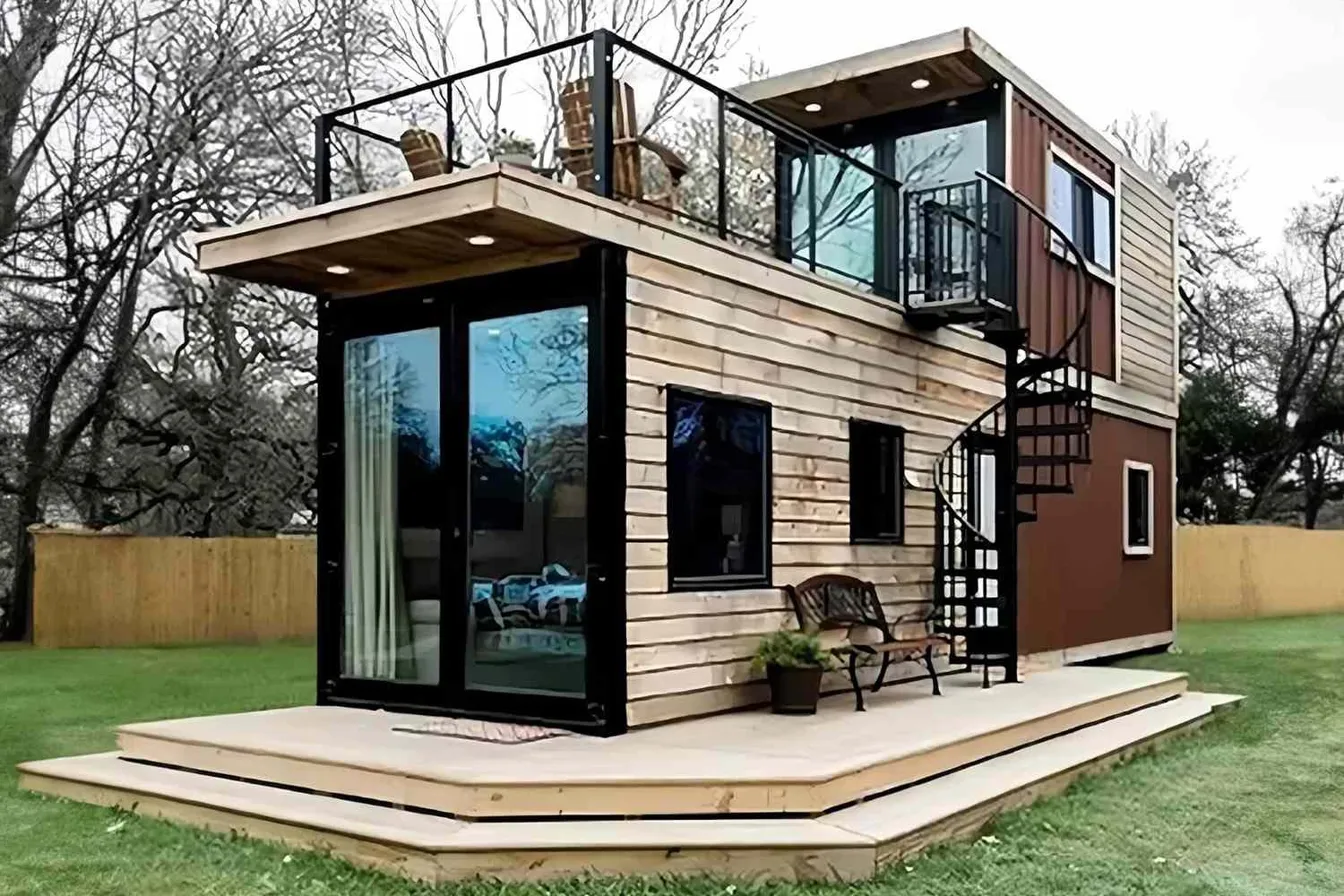 Two-story container home with rooftop balcony and spiral staircase